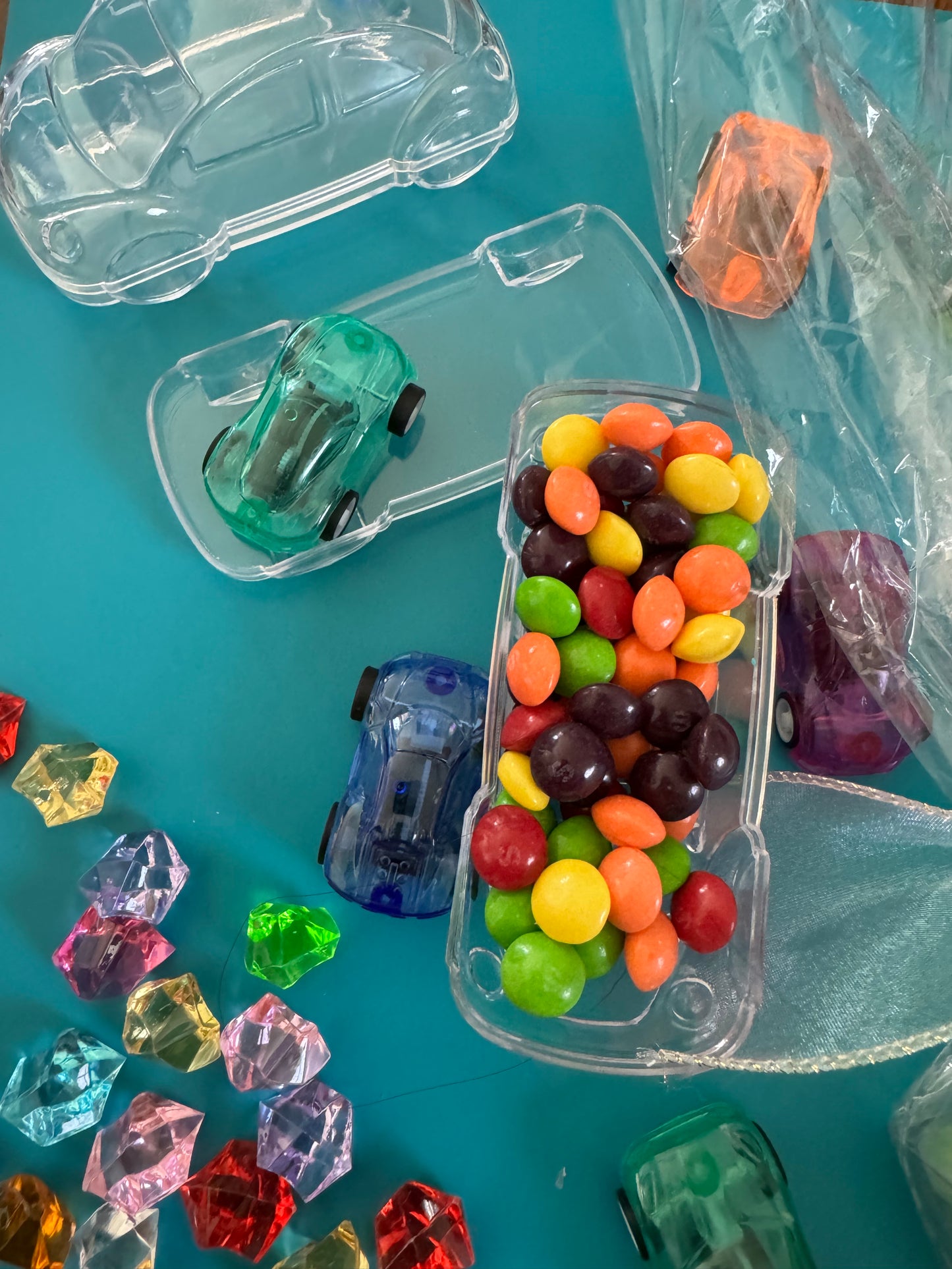 Car-themed candy favors, perfect for birthdays or playdates. Includes car-themed gummies or rainbow Skittles in a car-shaped box. Wrapped in cellophane with optional thank you label. Fun and delicious treat for any party. Custom candy containers available.