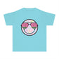 Kids’ summer t-shirt with a leopard print smiley face and watermelon sunglasses. Soft, durable cotton, available in youth sizes XS-XL. Perfect for summer activities.