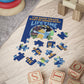 30-piece Bluey-inspired kids' puzzle made from laminated chipboard, featuring large pieces with rounded corners for safety. Ideal for toddlers, includes a reference photo for problem-solving, measuring 14" x 11"