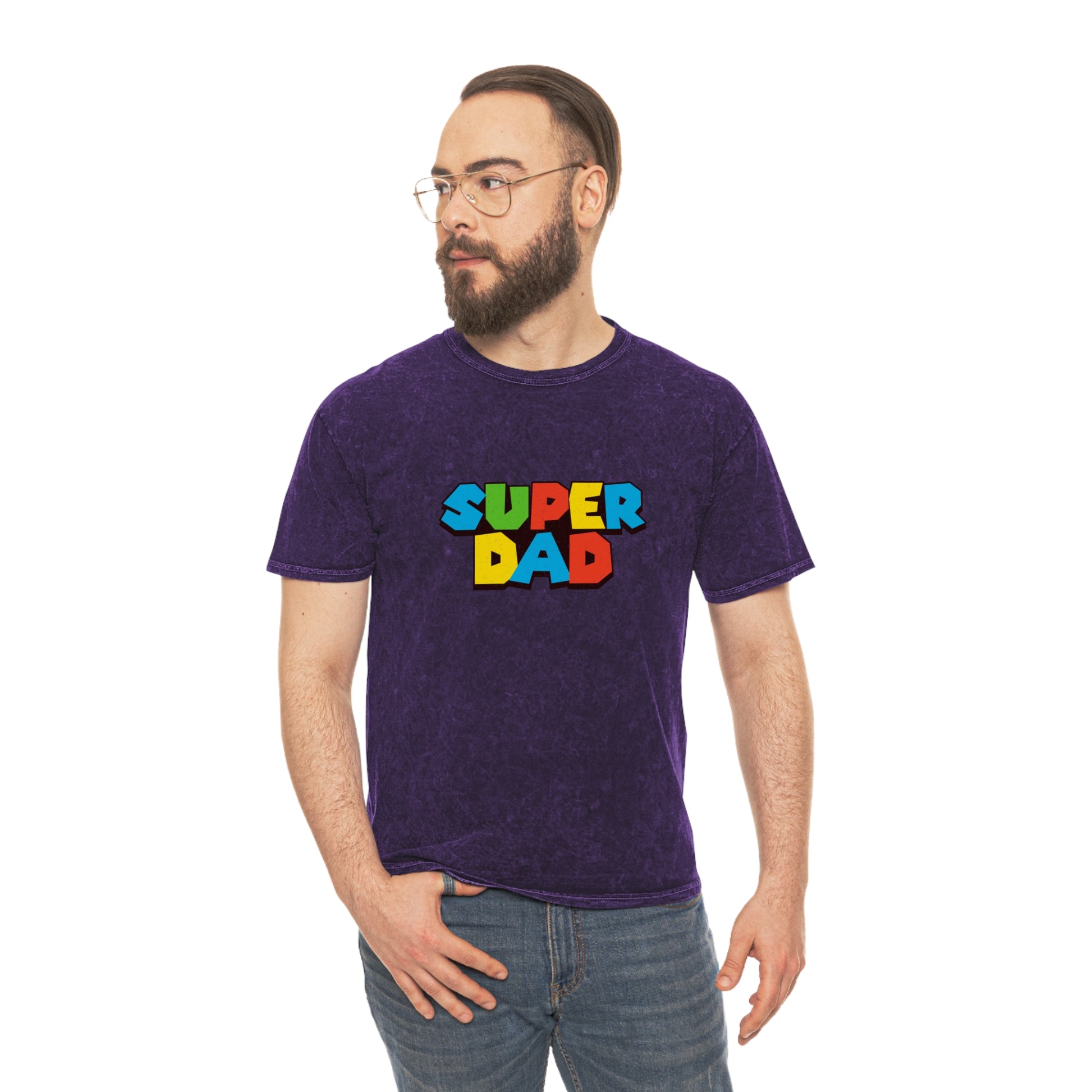 Super Mario-inspired retro 80s Father’s Day shirt for gamer dads. Soft 100% cotton with a nostalgic mineral wash effect, featuring a classic crewneck and 'SUPER DAD' graphic in colorful block letters. Available in black, gray, navy, and purple, men’s sizes small to 2XL. Perfect geeky dad gift for birthdays or Father’s Day.