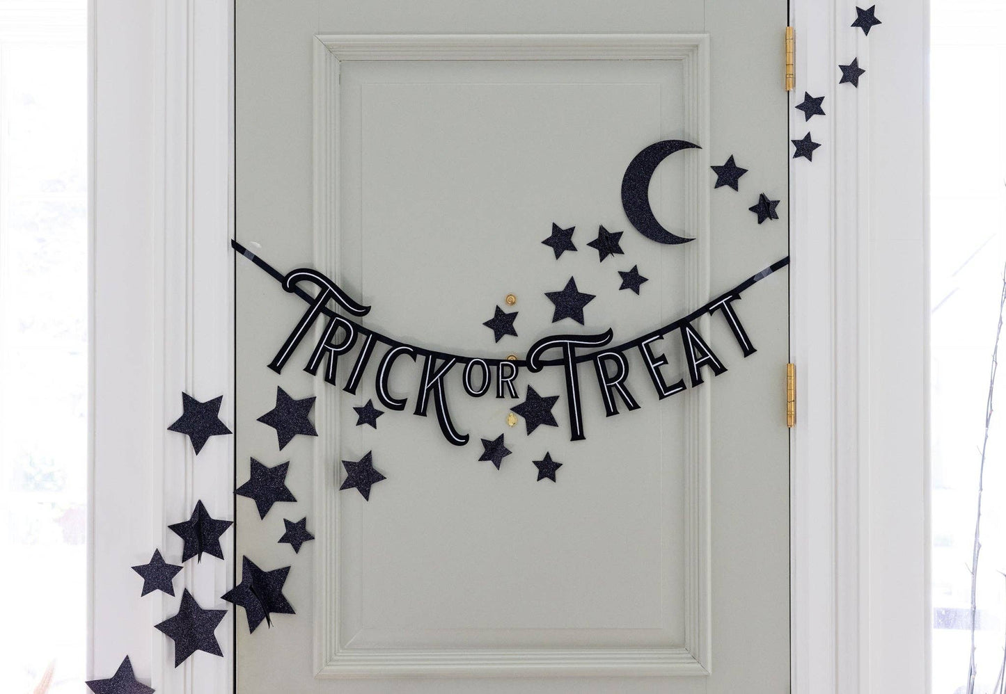 Black glitter star and moon wall décor, featuring 50 shimmering stars and 1 crescent moon, perfect for adding a magical touch to Halloween-themed spaces.