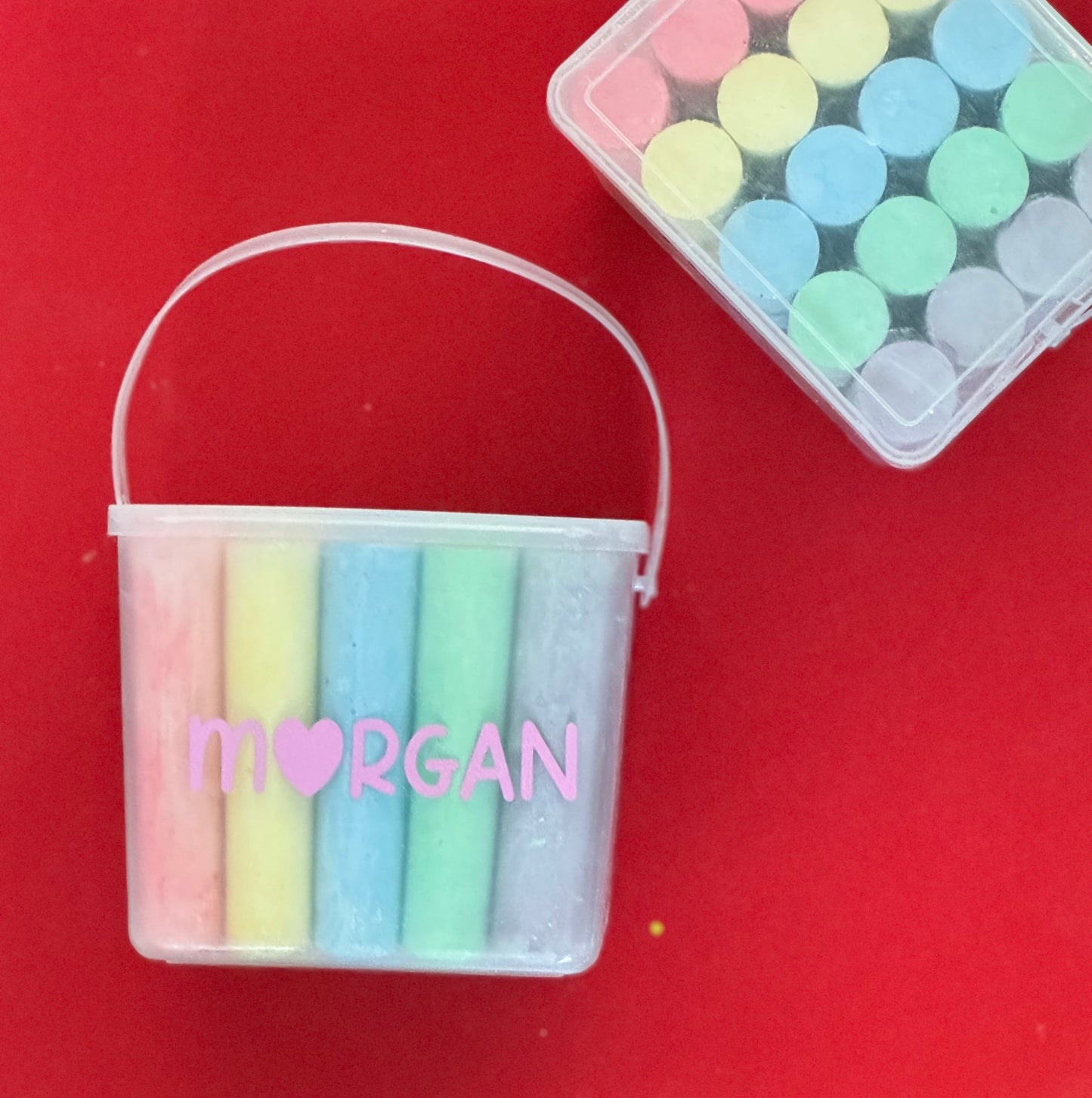 Personalized chalk bucket with 20 pieces of non-toxic chalk, featuring a handle and optional chalk holder. Ideal for outdoor fun or classrooms, easy to clean with water. Includes custom label and wrapping. Perfect for party favors or gifts.