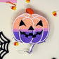 Groovy mini pumpkin piñata with orange, lavender, and pink colors for a boho Halloween vibe. Measures 5 inches tall and long, with a 1.5-inch width, featuring a trap door for treats. Perfect for Halloween decor or party favors for kids and family.