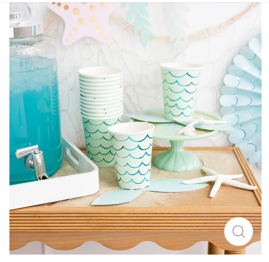 Mermaid Tail Paper Party Cups with adhesive tail and aqua foil accents, perfect for under-the-sea themed celebrations. Includes 8 cups per package, 12 oz capacity, measuring 4.5" tall and 3.5" round at the top