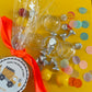 Construction-themed candy favor in plastic helmet containers with chocolate kisses and themed labels. Wrapped in cellophane with optional thank you label. Ideal for construction-themed parties and events.