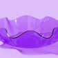 Colorful 8" diameter wavy bowl made of purple acrylic, 3" tall, perfect for parties, desk decor, or as a catch-all bowl. Imported and stylish, ideal for vibrant kitchenware and modern home decor.