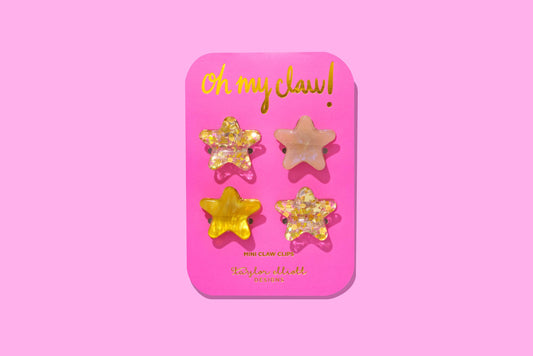 Set of 4 mini star-shaped claw clips, gold confetti and acetate, perfect for everyday wear and gifts.