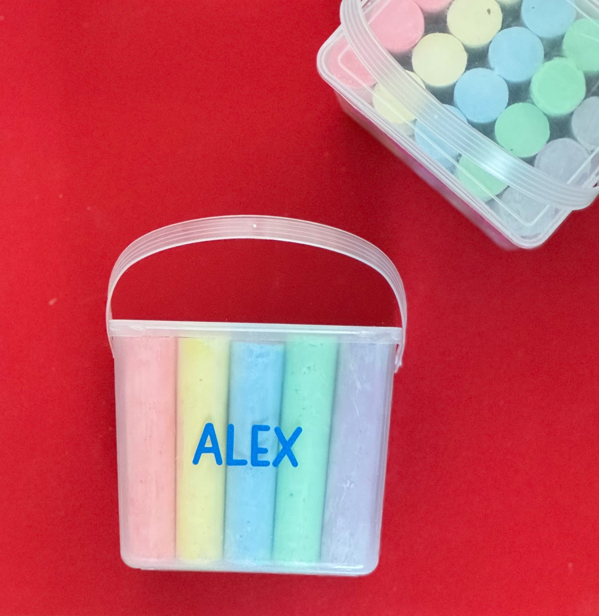 Personalized chalk bucket with 20 pieces of non-toxic chalk, featuring a handle and optional chalk holder. Ideal for outdoor fun or classrooms, easy to clean with water. Includes custom label and wrapping. Perfect for party favors or gifts.