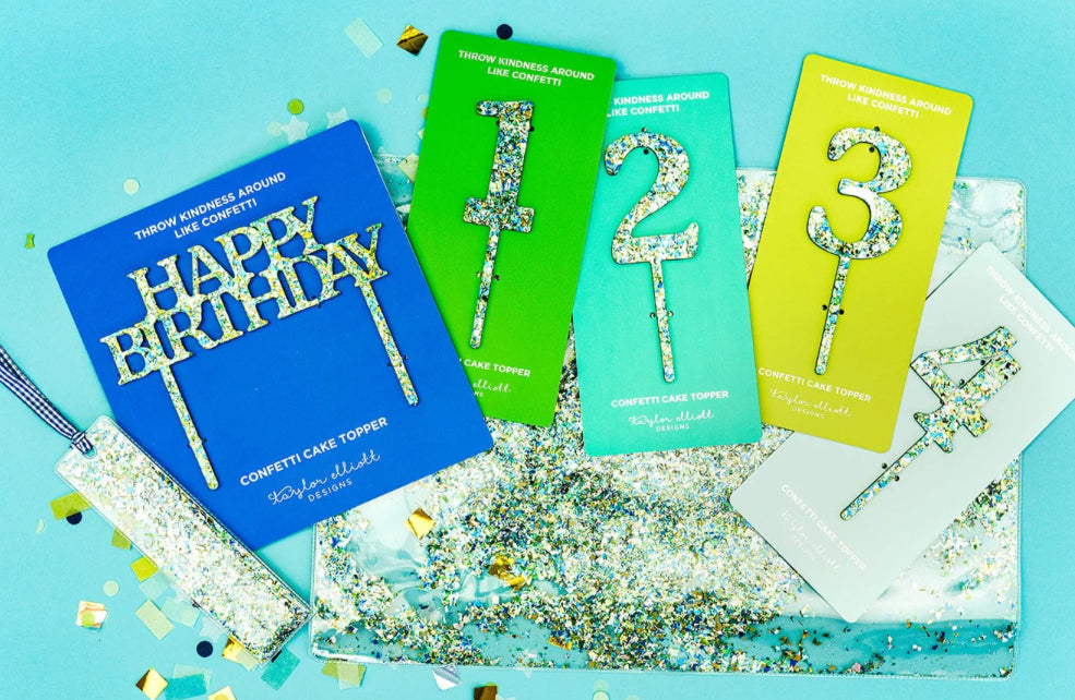 Delightful confetti bookmark for books, planners, or Bibles, measuring 2" x 7". Made of clear plastic with blue and green confetti, finished with a blue gingham ribbon.