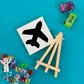 Airplane-themed DIY painting kits, perfect party favors for kids ages 3+. Each kit includes a canvas with a peel-away themed design, wooden easel, paint set, and paintbrush. Ideal for birthdays, baby showers, and sleepover parties. Rainbow easels available as an add-on. Fun indoor activity for toddlers and preschoolers.