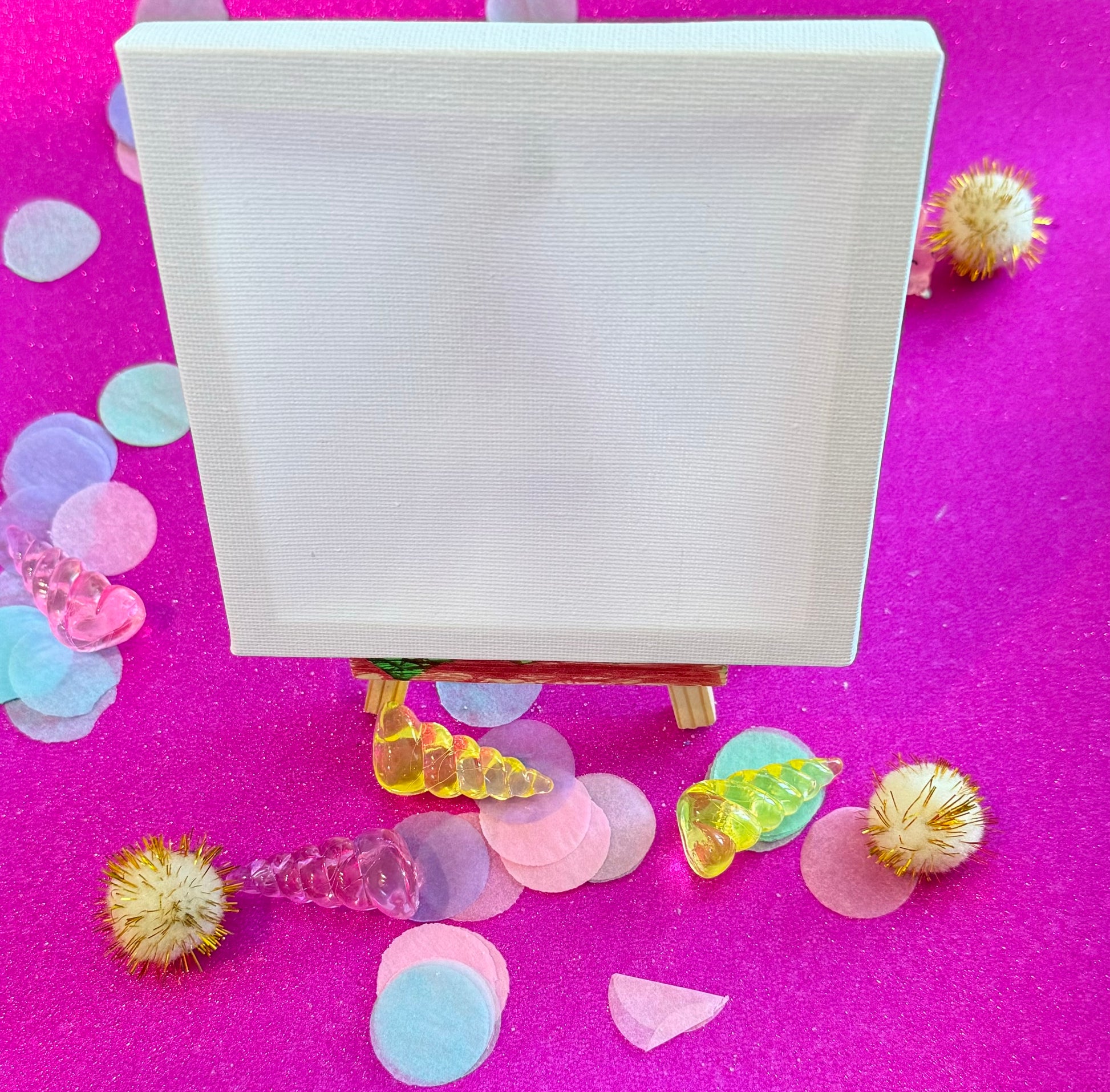 Unicorn paint party kit for kids with canvas, tiny easel, paints, and brush. Features peel-off unicorn stickers for easy painting. Ideal for birthdays, art classes, or party favors. Optional rainbow confetti easel upgrade available