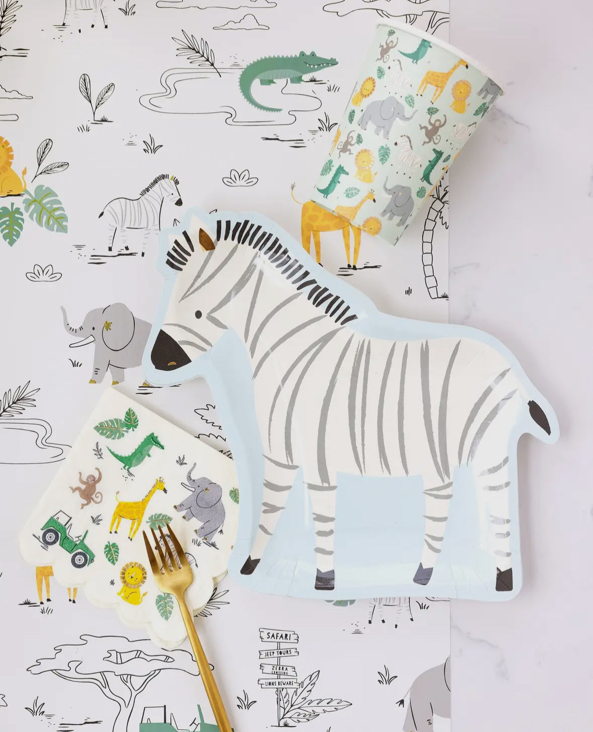 Zebra-shaped paper plates featuring a whimsical zebra illustration with gold foil accents. Includes 8 plates, approximately 11" wide and 10" tall. Perfect for adding a fun and wild touch to a safari-themed birthday party table decor.