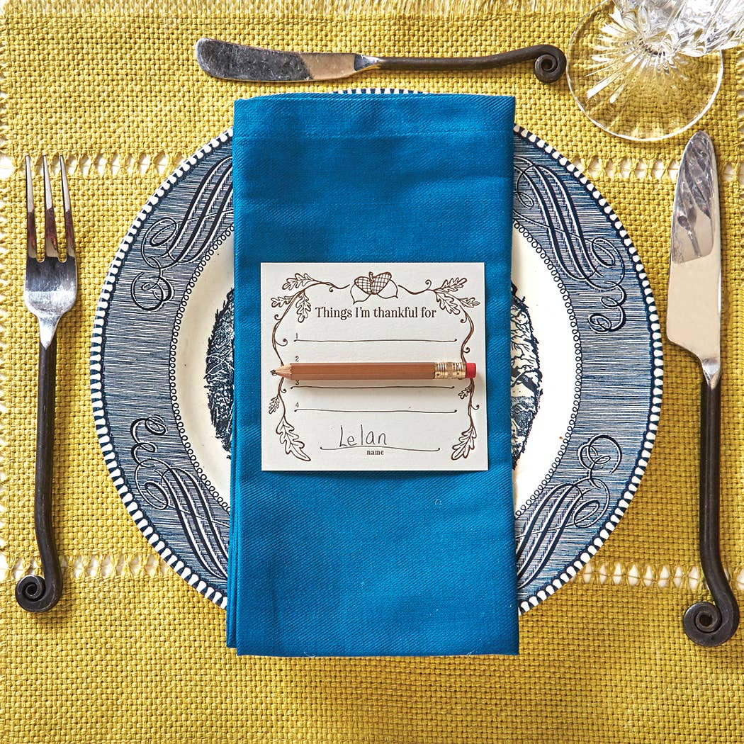 Interactive dinner party place cards with mini gold pencils, designed to spark conversations and create memories during holidays. Set of 8 letterpress printed 4"x3.75" flat cards, perfect for seating arrangements and table settings. Packaged in a clear box.