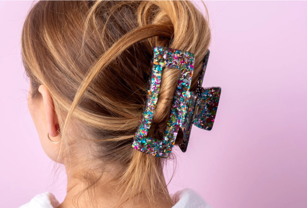 Sparkly 4-inch claw clip featuring colorful confetti, perfect for holding hair securely while adding a touch of style to any outfit. Ideal for everyday wear or special occasions, this durable hair accessory is a must-have for fashion-forward individuals.