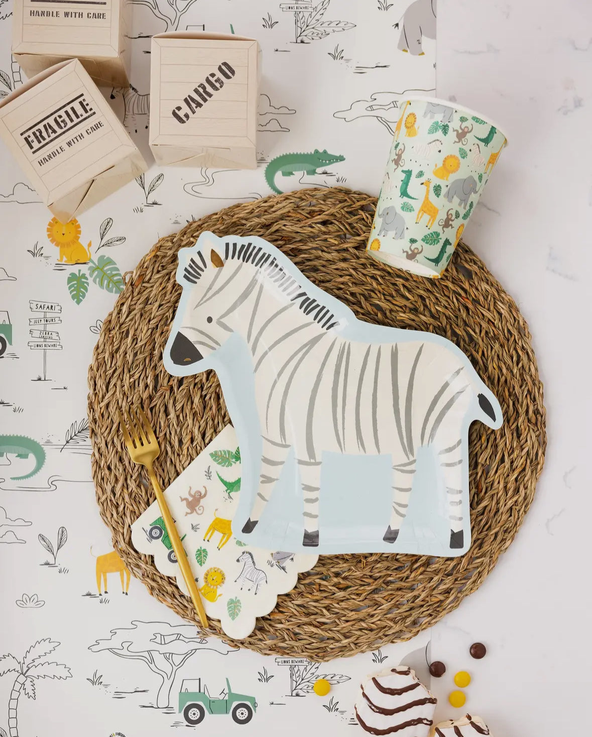 Zebra-shaped paper plates featuring a whimsical zebra illustration with gold foil accents. Includes 8 plates, approximately 11" wide and 10" tall. Perfect for adding a fun and wild touch to a safari-themed birthday party table decor.