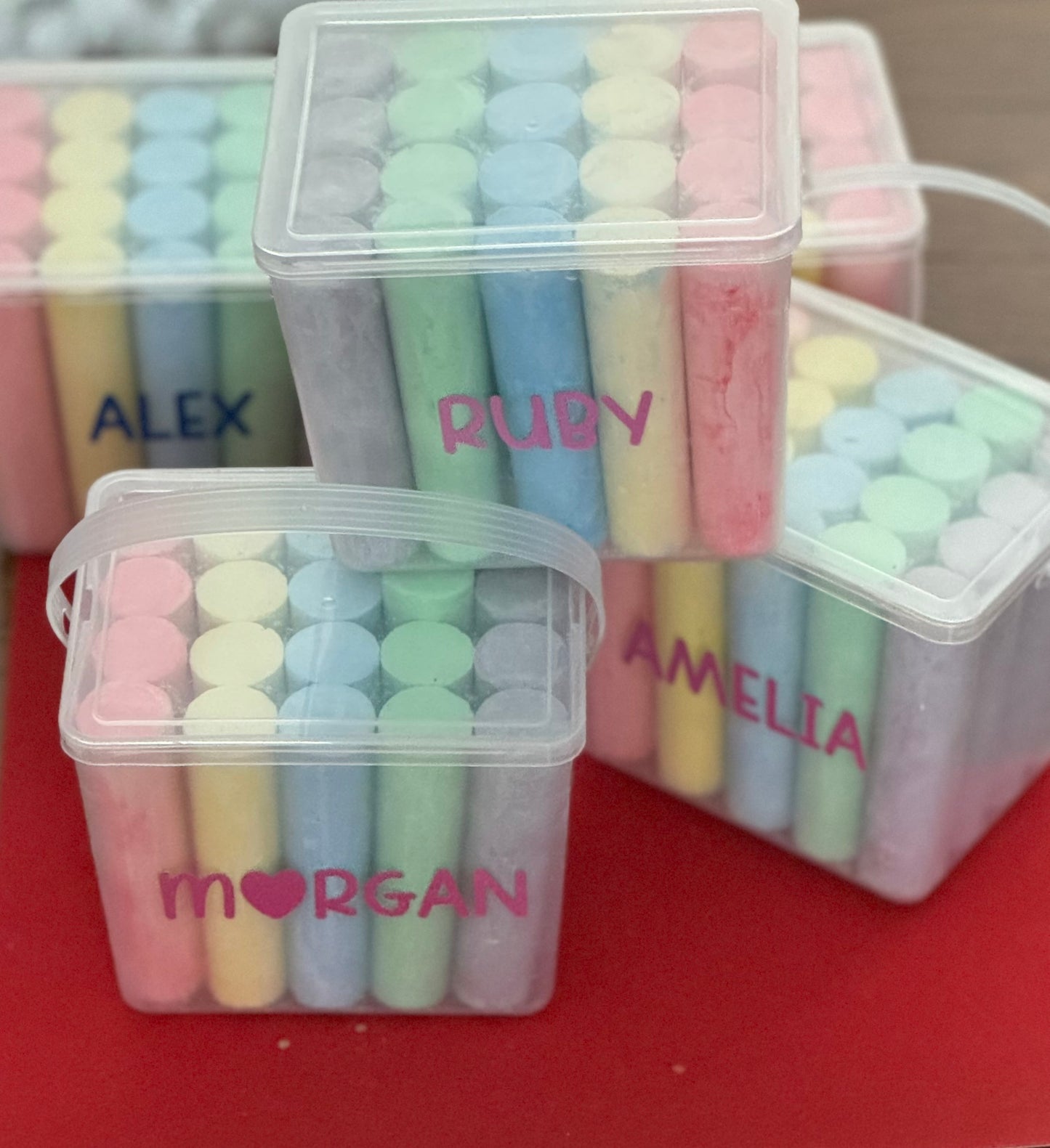 Personalized chalk bucket with 20 pieces of non-toxic chalk, featuring a handle and optional chalk holder. Ideal for outdoor fun or classrooms, easy to clean with water. Includes custom label and wrapping. Perfect for party favors or gifts.