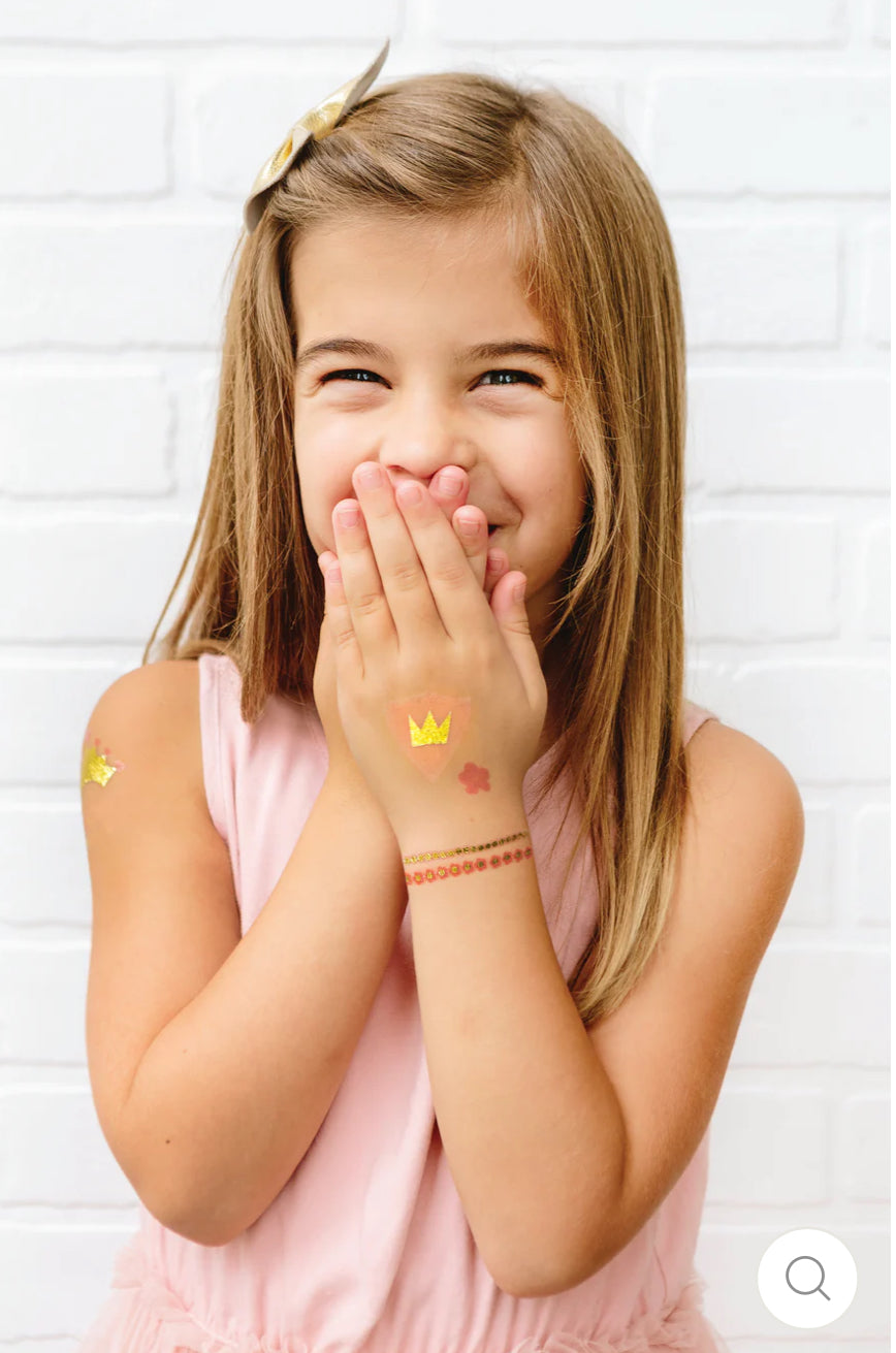 Princess-themed temporary tattoos featuring pretty pinks and gold foil accents. Includes 40 tattoos, 2 of each design, perfect for party favors or use at the event. Add them to Princess Castle Favor Boxes for a magical fairy tale party experience.