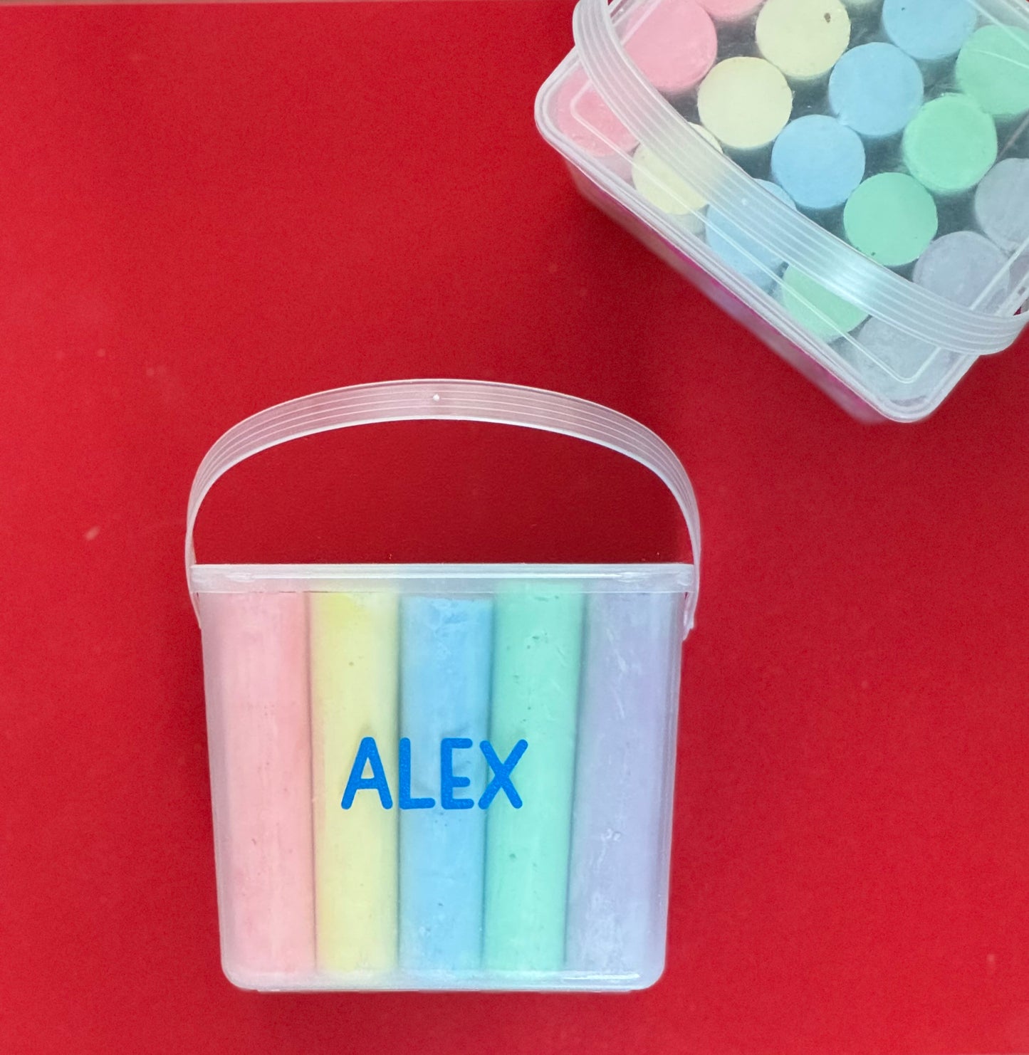 Personalized chalk bucket with 20 pieces of non-toxic chalk, featuring a handle and optional chalk holder. Ideal for outdoor fun or classrooms, easy to clean with water. Includes custom label and wrapping. Perfect for party favors or gifts.