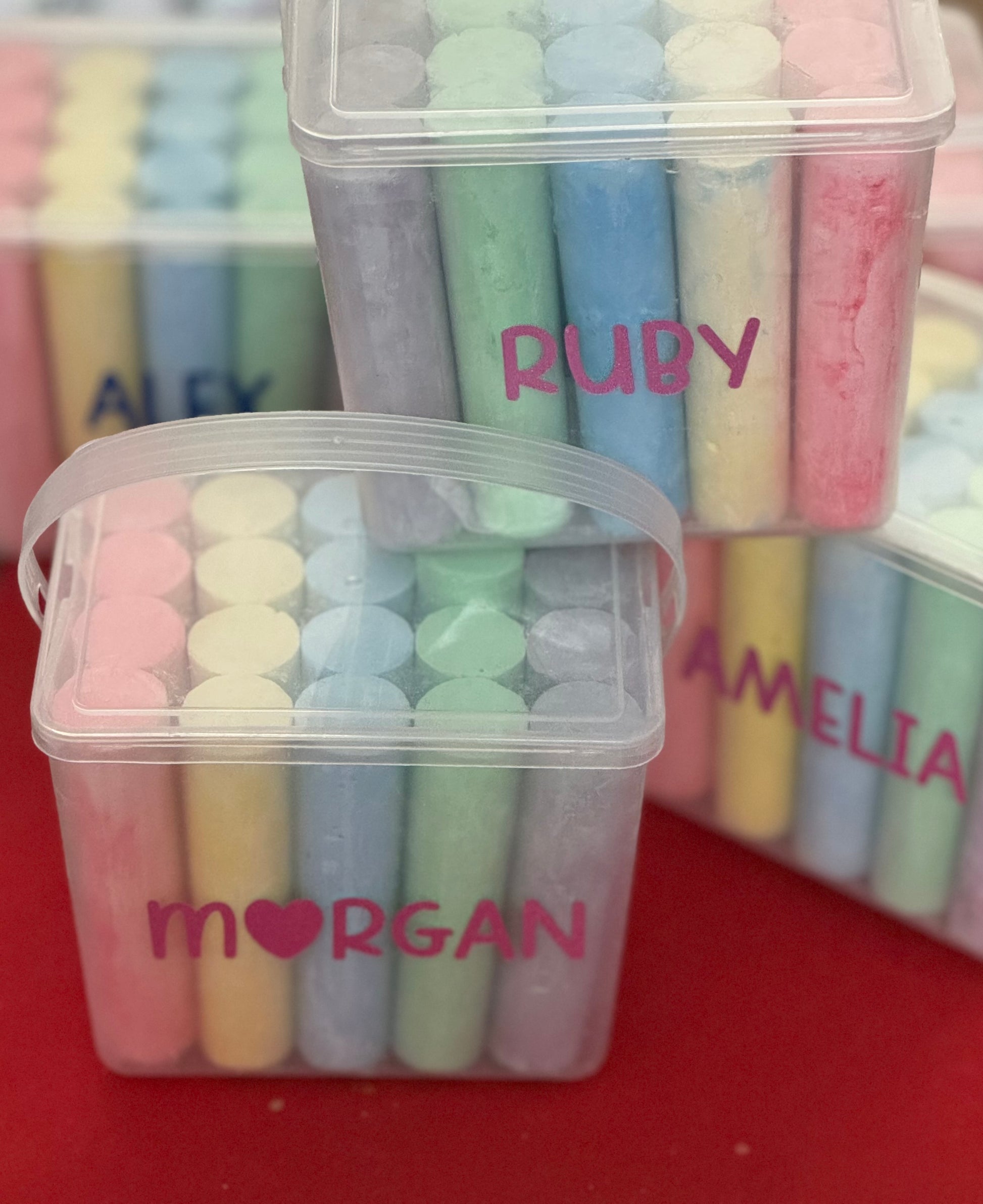 Personalized chalk bucket with 20 pieces of non-toxic chalk, featuring a handle and optional chalk holder. Ideal for outdoor fun or classrooms, easy to clean with water. Includes custom label and wrapping. Perfect for party favors or gifts.