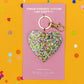 Confetti acrylic heart keychain, 3" x 3" with a gold metal keyring. Perfect for adding to keys, tote bags, or backpacks. Confetti is hand-sprinkled inside the acrylic to prevent shedding. Each piece is unique due to this process. Includes silver hologram foil.