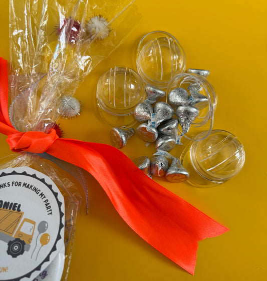 Construction-themed candy favor in plastic helmet containers with chocolate kisses and themed labels. Wrapped in cellophane with optional thank you label. Ideal for construction-themed parties and events.