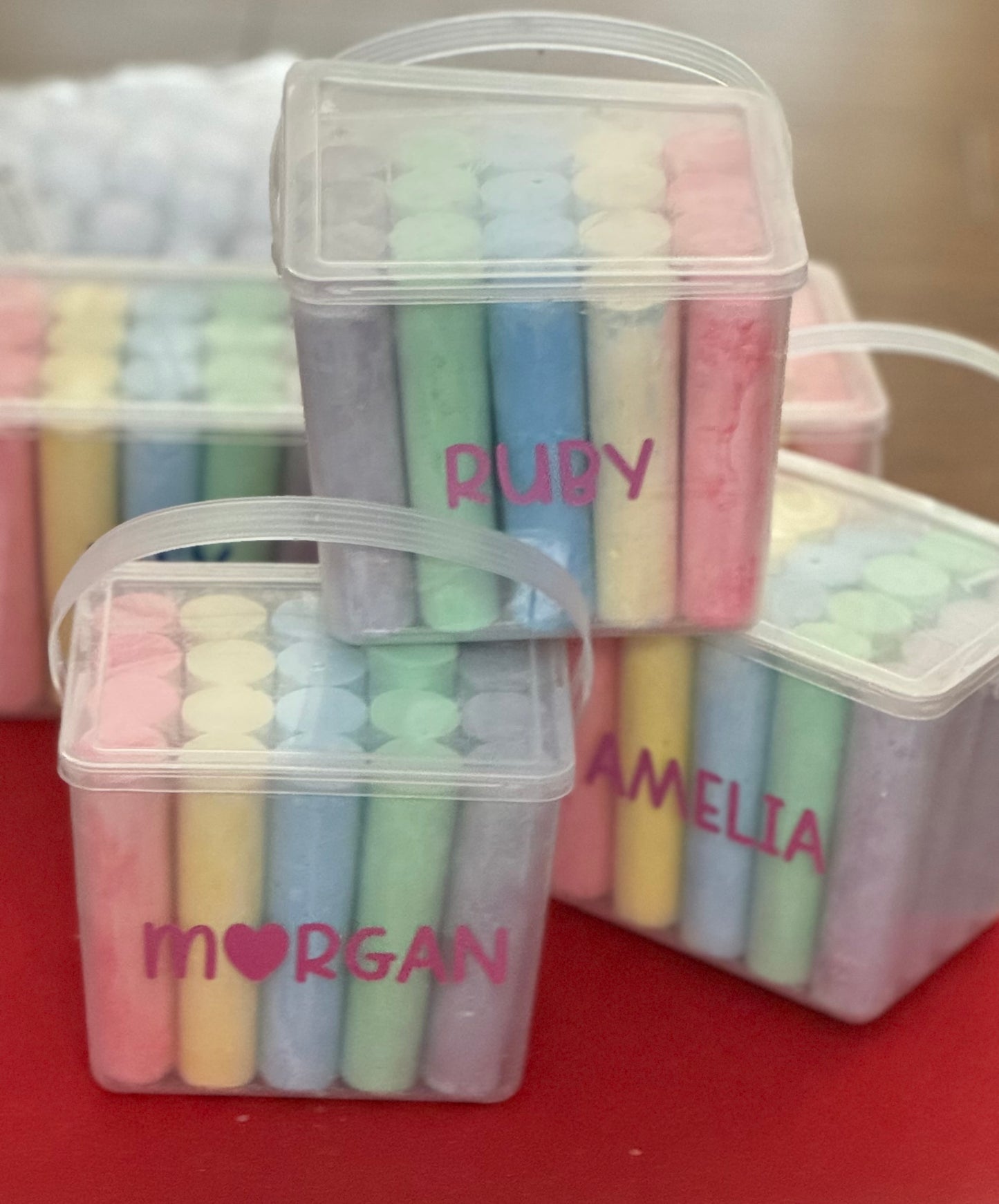 Personalized chalk bucket with 20 pieces of non-toxic chalk, featuring a handle and optional chalk holder. Ideal for outdoor fun or classrooms, easy to clean with water. Includes custom label and wrapping. Perfect for party favors or gifts.