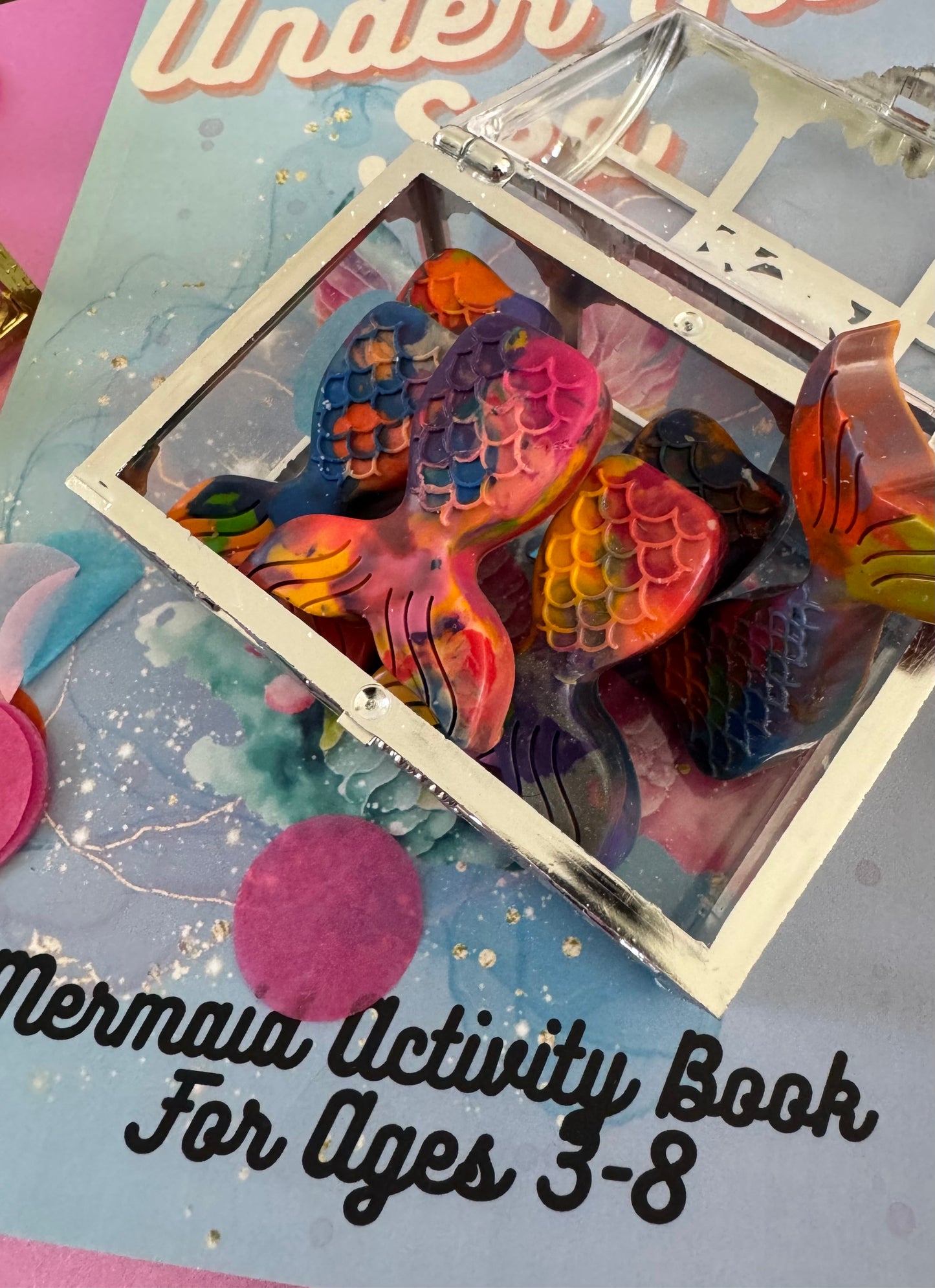 Mermaid tail-shaped crayons in a treasure chest gift box, perfect party favor for kids ages 3-8. Available in multicolor or solid colors, handmade in the USA with 100% non-toxic crayons. Great for school events, birthdays, or non-candy favors. Parental supervision advised due to small parts