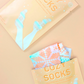 Cozy Socks Smoothing Foot Masks enriched with cocoa butter and peppermint oil, designed to hydrate and heal dry, cracked feet, featuring a fun fair isle print for a festive and relaxing self-care experience.