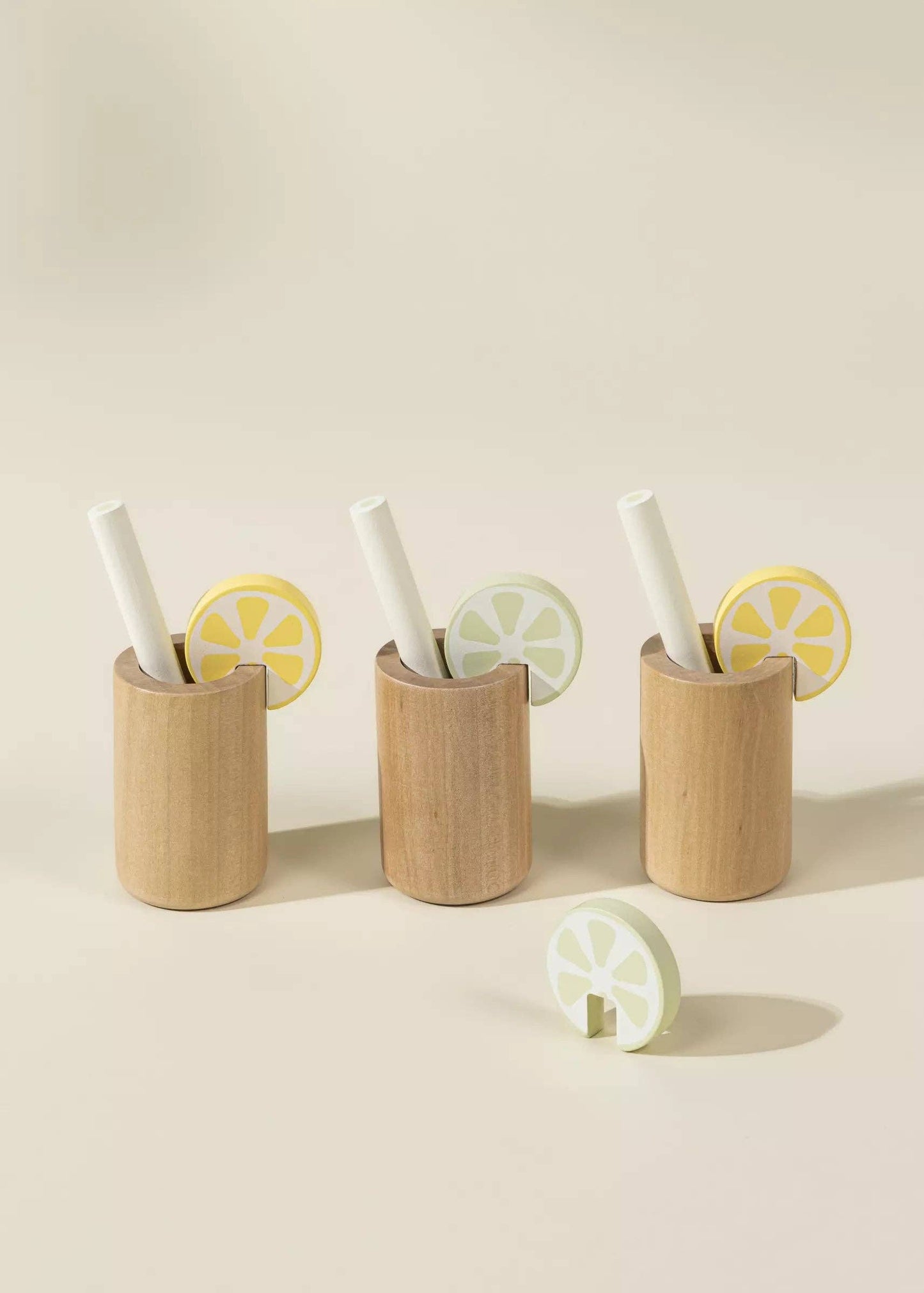 Wooden Lemonade Playset for kids featuring 3 glasses, 3 straws, pitcher, lime and lemon slices, and a cuttable lemon. Perfect for imaginative play, fostering creativity, cognitive development, and role-play as they run their own lemonade stand.