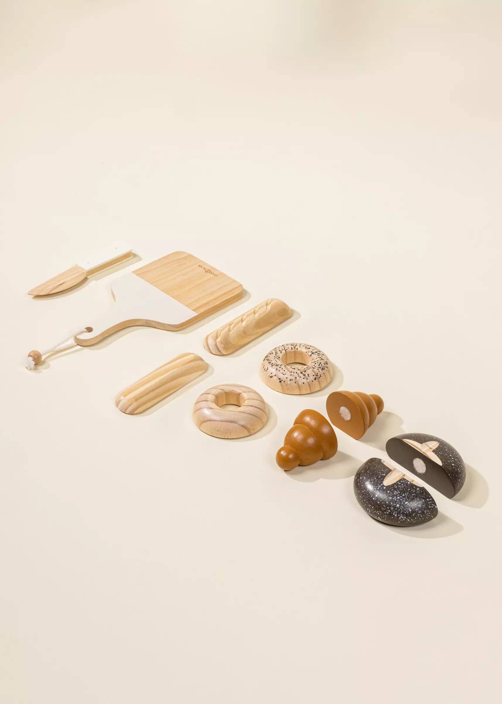 Wooden Bakery Playset for kids with baguette, croissant, pumpernickel, bagel, cutting board, and knife. Ideal for imaginative market play, helping children learn about different bread types, healthy eating, and colors. Perfect for pretend play with kitchen and market sets