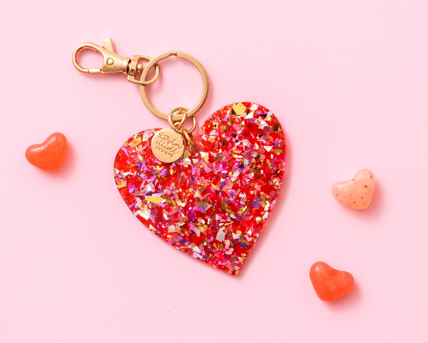 a heart shaped keychain on a pink background