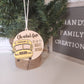 A festive Christmas tree ornament featuring a wooden design with a yellow school bus and the text 'Oh what fun it is to ride 2023.' The ornament hangs on a small Christmas tree with a burlap base, adding a personalized touch to holiday decor.
