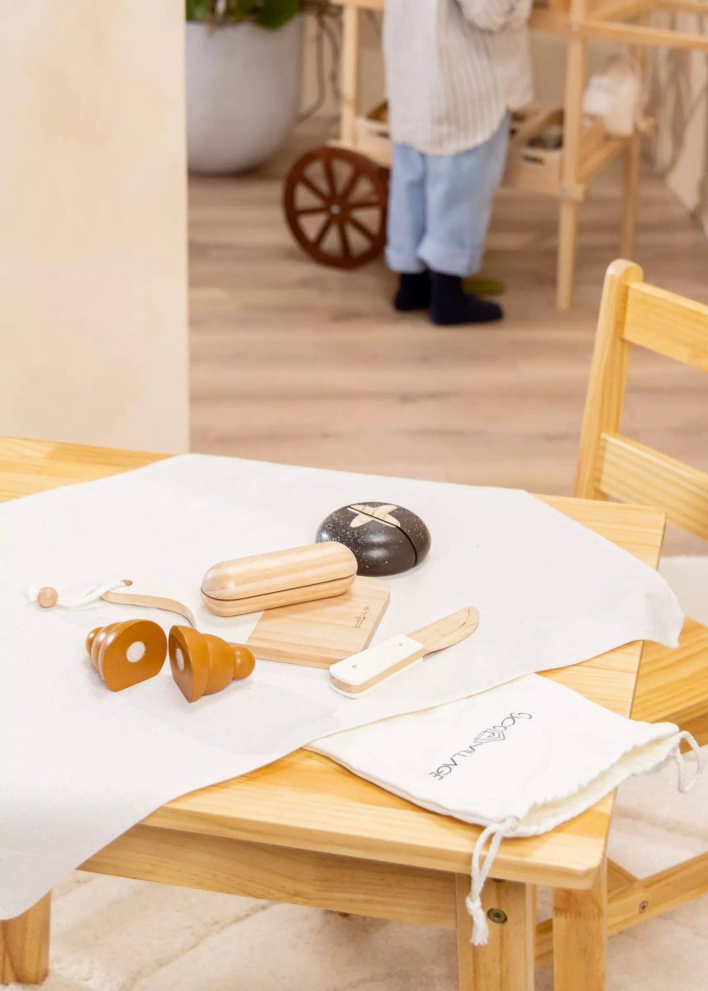 Wooden Bakery Playset for kids with baguette, croissant, pumpernickel, bagel, cutting board, and knife. Ideal for imaginative market play, helping children learn about different bread types, healthy eating, and colors. Perfect for pretend play with kitchen and market sets