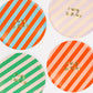 Bold striped birthday plates with gold foil 'Happy Birthday' text, pack of 8, 4 vibrant colors.